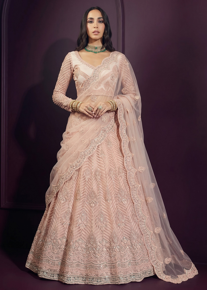 Buy Now Pinkish Peach Net Embroidered Bridesmaids Lehenga Choli Online in US, UK, Canada, France, Italy, Greece, Sweden, Netherlands, UAE &amp; Worldwide at Empress.