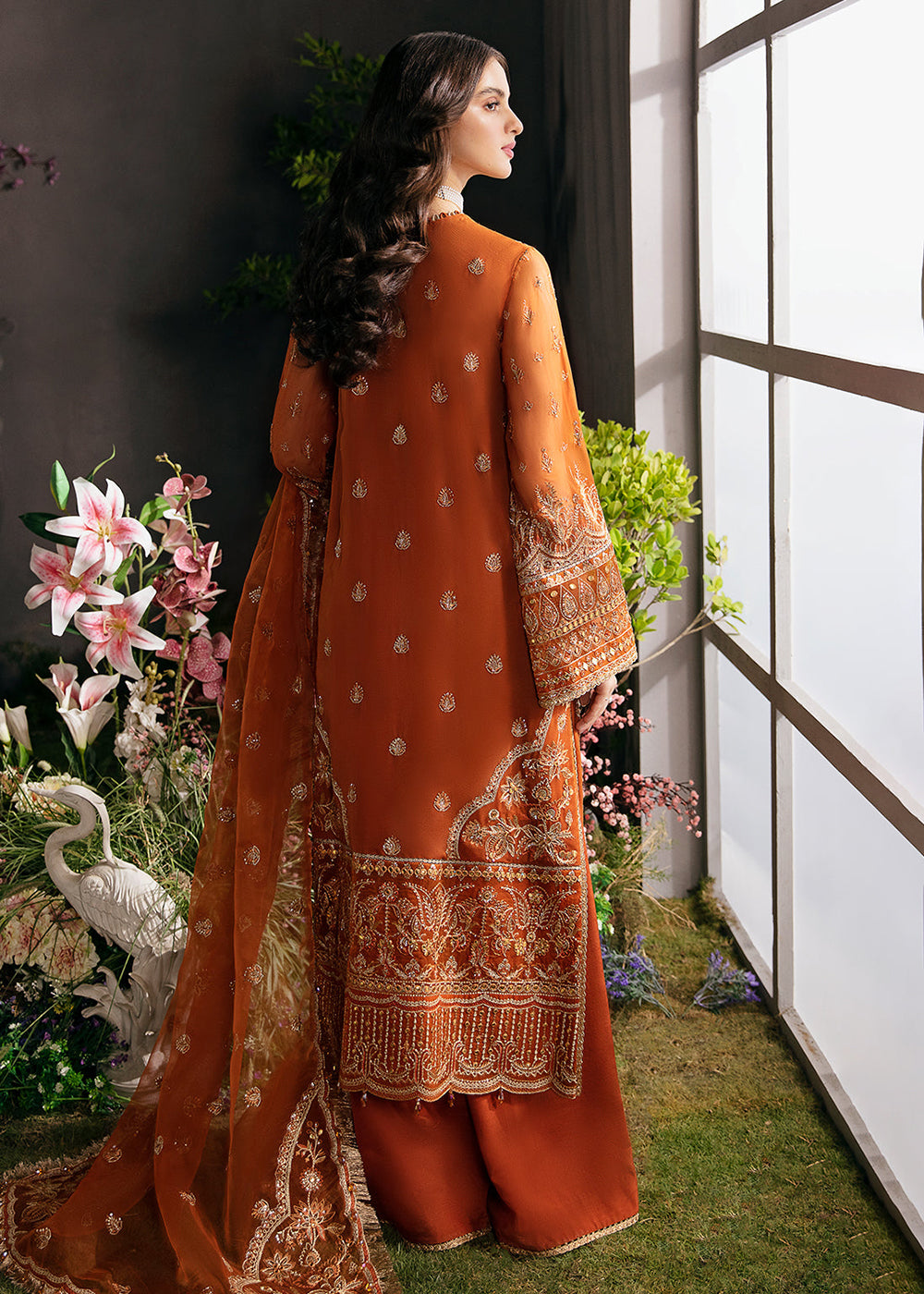 afrozeh orange dress Aafreen A rich burnt-orange ensemble designed with structured elegance and detailed craftsmanship. The long silhouette features vertical panels of intricate gold embroidery, giving the outfit height and definition while keeping the surface