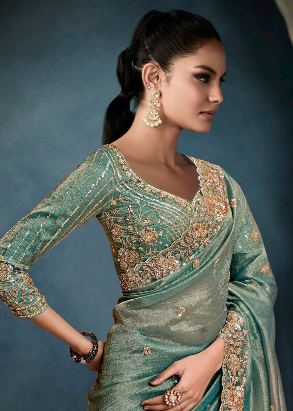 Radiant Teal Green tissue saree with intricate handwork & cutwork embroidery. Includes matching blouse piece. Perfect for wedding & festivals. Shop Now.