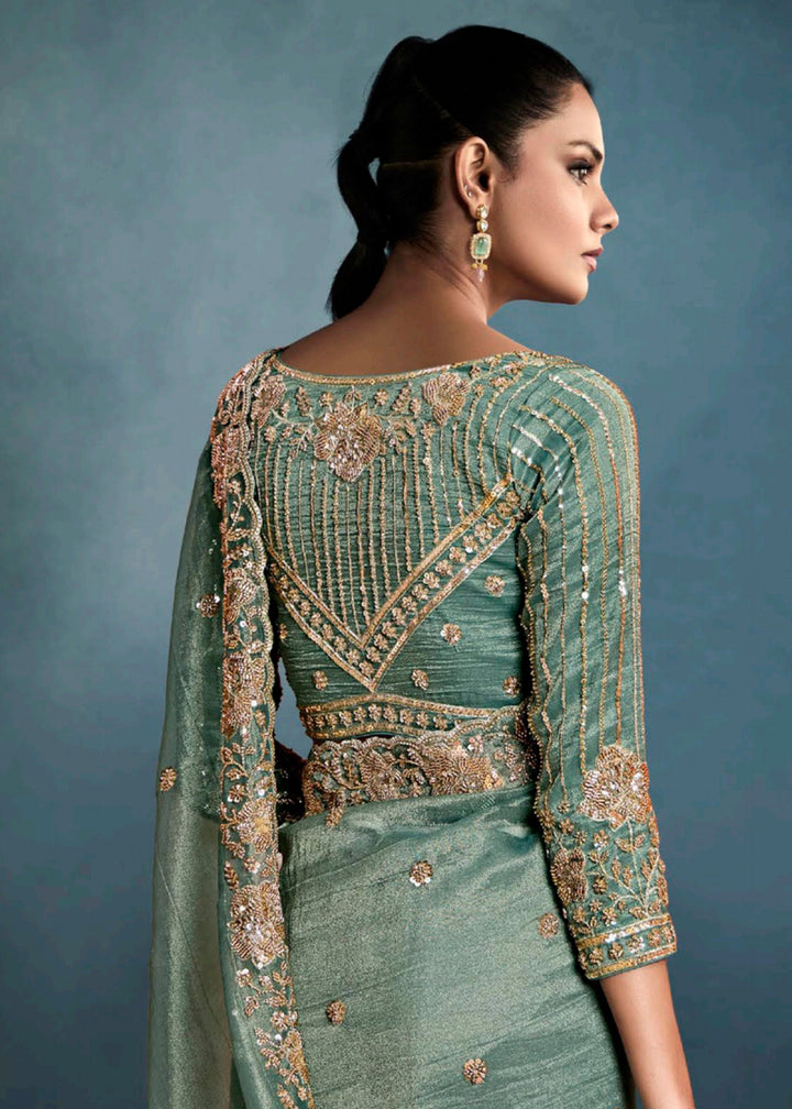 Radiant Teal Green tissue saree with intricate handwork & cutwork embroidery. Includes matching blouse piece. Perfect for wedding & festivals. Shop Now.