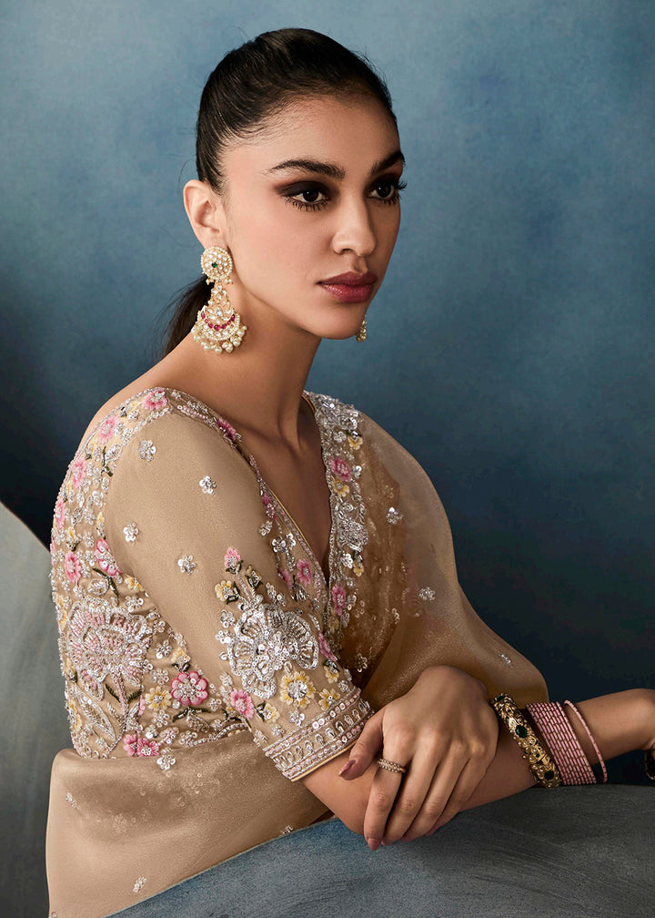 Radiant Beige tissue saree with intricate handwork & cutwork embroidery. Includes matching blouse piece. Perfect for wedding & festivals. Shop Now.