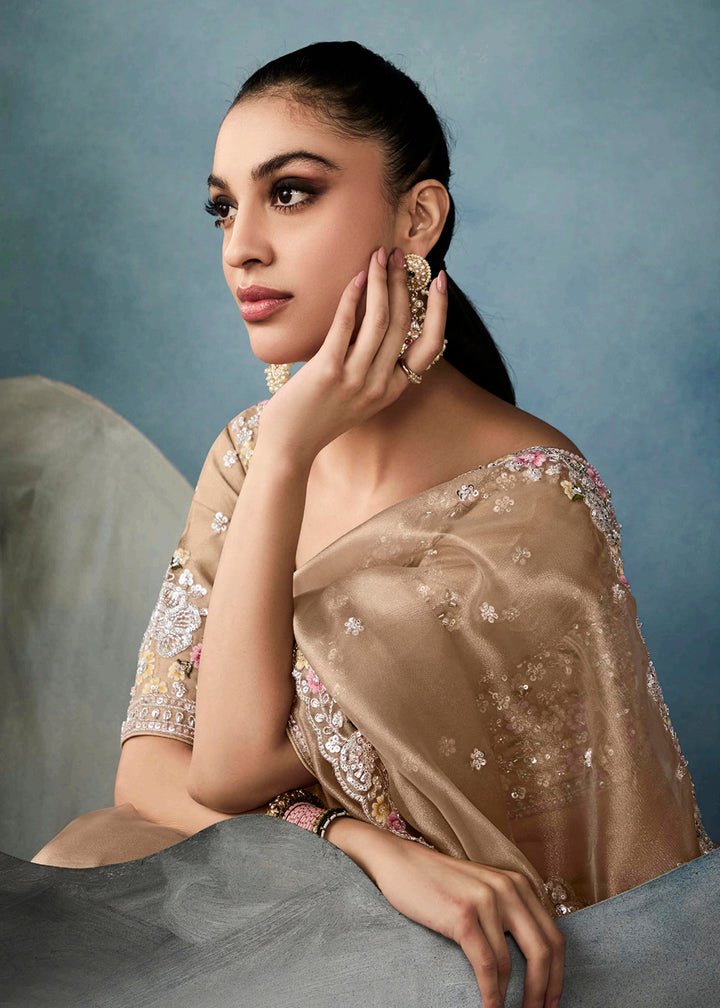 Radiant Beige tissue saree with intricate handwork & cutwork embroidery. Includes matching blouse piece. Perfect for wedding & festivals. Shop Now.