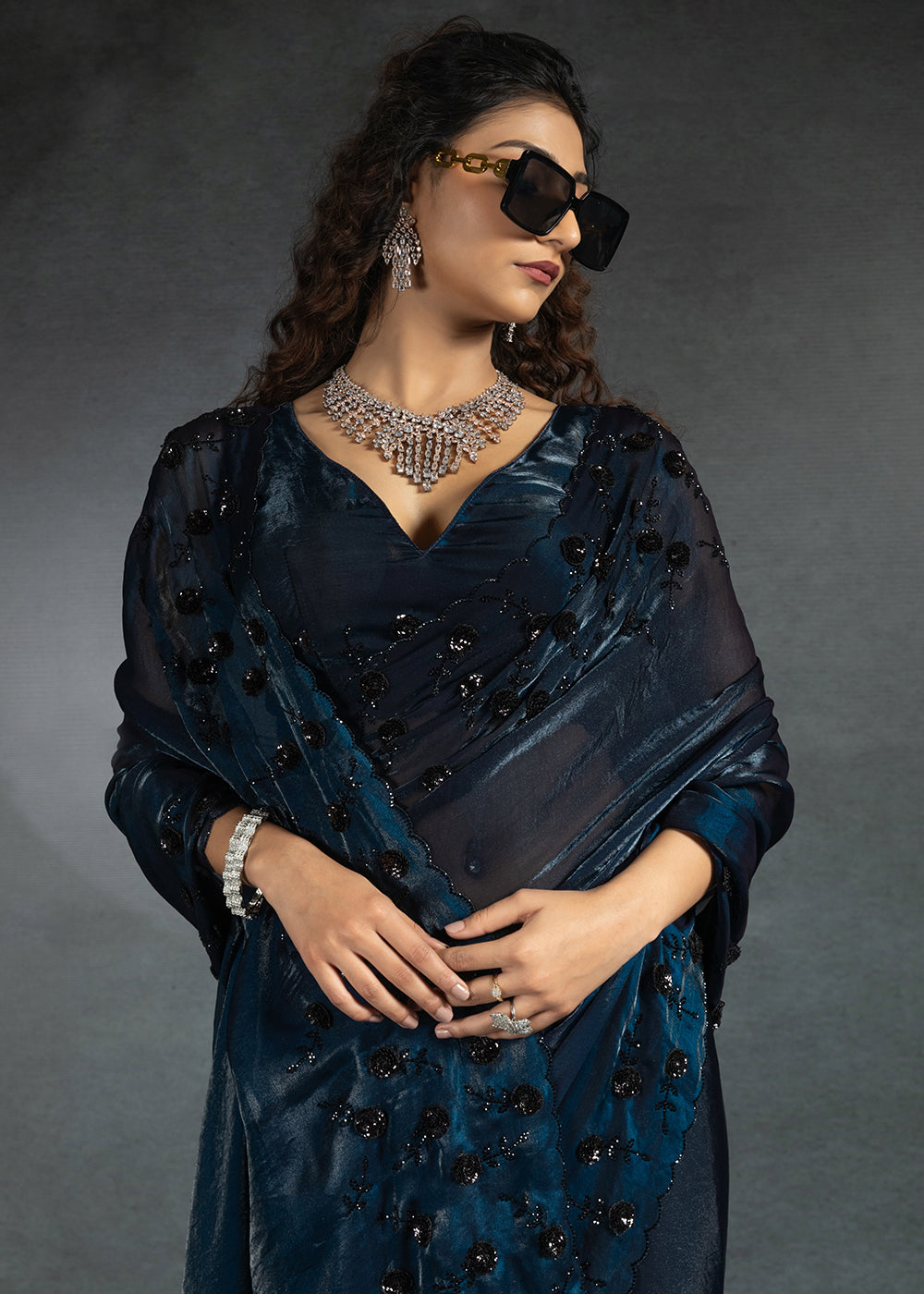 Gleaming Blue satin silk saree with intricate handwork, sequins, cutwork & zarkan embroidery. Includes matching blouse piece. Perfect for wedding parties.