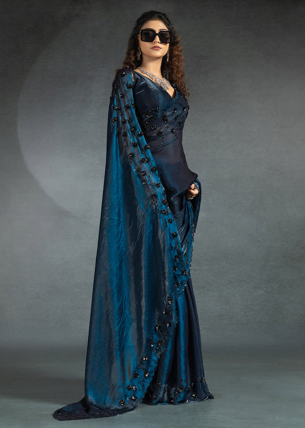 Gleaming Blue satin silk saree with intricate handwork, sequins, cutwork & zarkan embroidery. Includes matching blouse piece. Perfect for wedding parties.