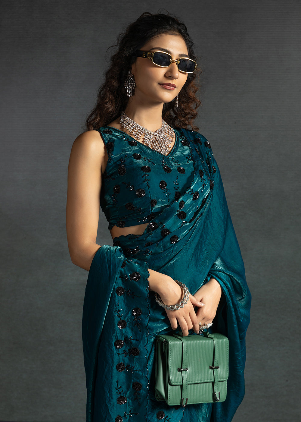 Gleaming Teal satin silk saree with intricate handwork, sequins, cutwork & zarkan embroidery. Includes matching blouse piece. Perfect for wedding parties.
