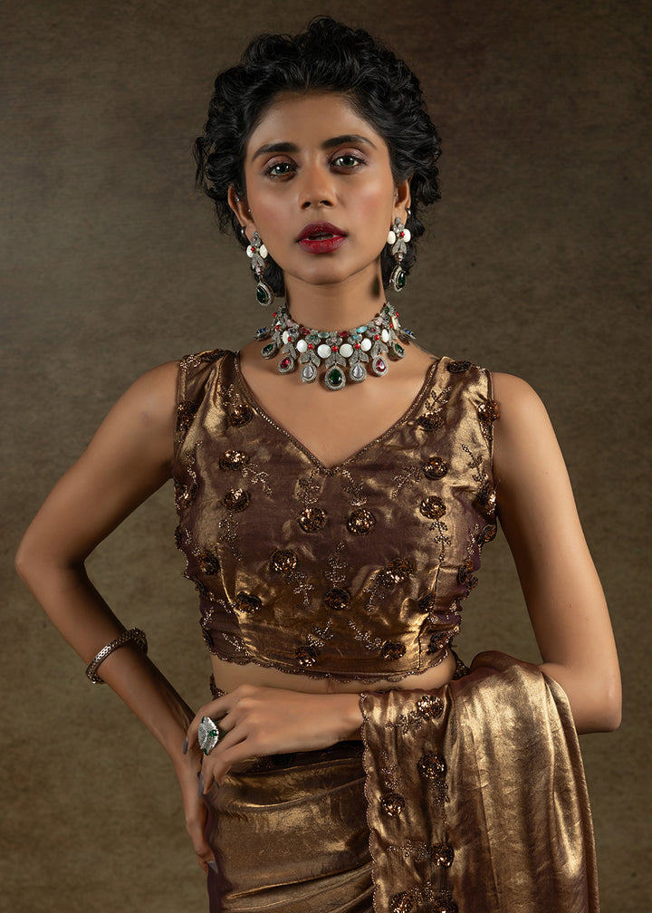 Luxurious golden satin silk saree with intricate handwork, sequins & zarkan embroidery. Includes matching blouse piece. Perfect for wedding parties. Buy now!