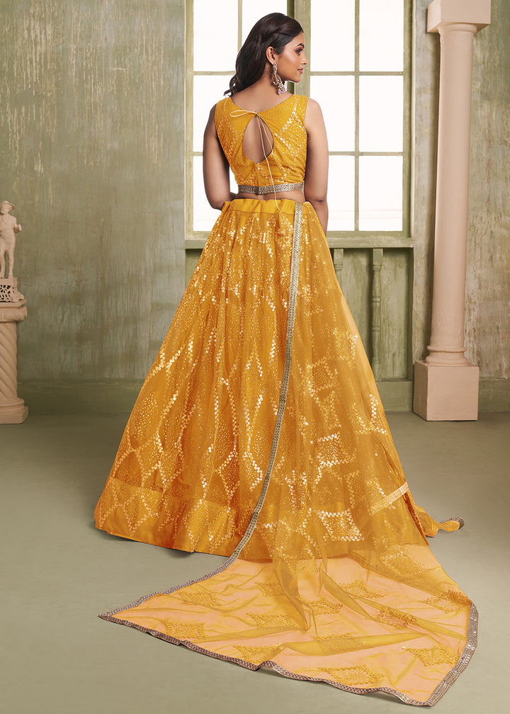 Buy Now Enchanting Mustard Net Wedding Festive Lehenga Choli Online in USA, UK, Canada, France, Italy, Germany, Sweden, Denmark &amp; Worldwide at Empress Clothing.