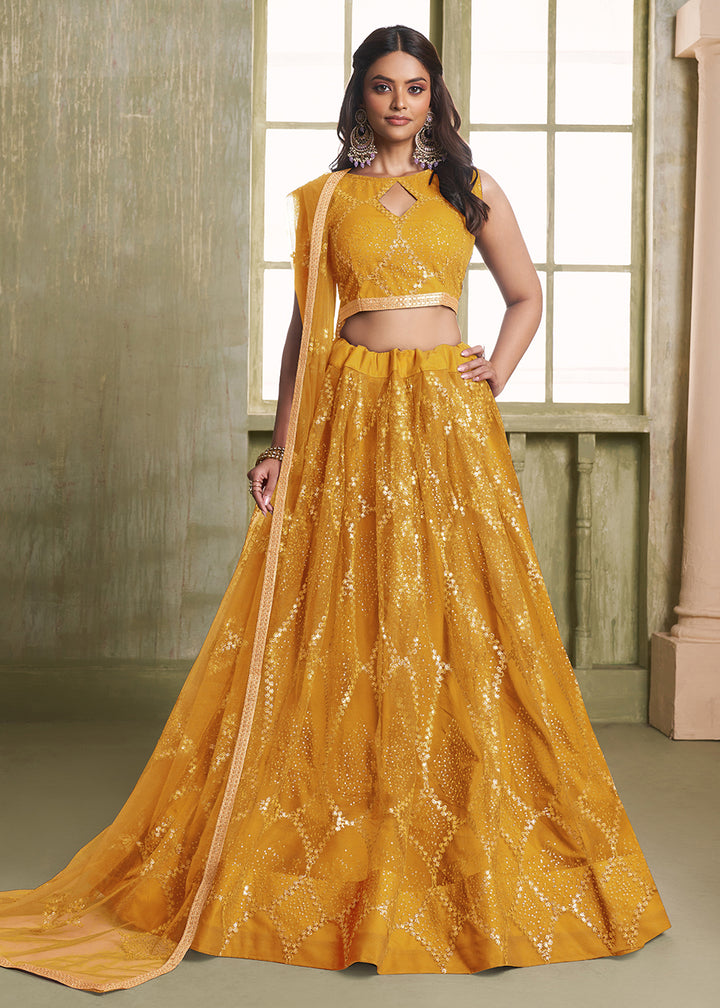 Buy Now Enchanting Mustard Net Wedding Festive Lehenga Choli Online in USA, UK, Canada, France, Italy, Germany, Sweden, Denmark &amp; Worldwide at Empress Clothing.